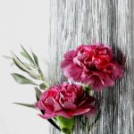 Wunderschöne rot-rosa Nelken lugen aus dem Lametta hervor