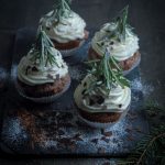 Wintercupcakes mit kleinen Tannen aus Rosmarin. Dekoriert wird mit Puderzucker, Zimt und Schokoladenflocken