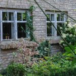 Gartenhaus aus recycelten Steinen und Fenstern